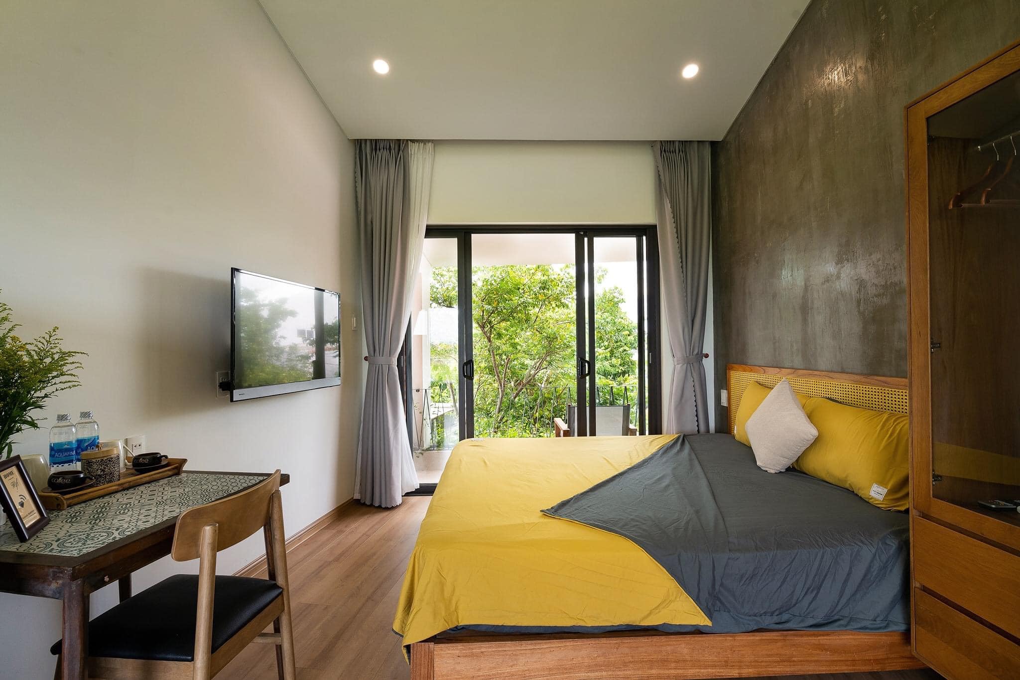 Phòng ngủ với sự kết hợp hài hòa giữa tường sơn màu nhẹ nhàng và bức tường đầu giường được để nguyên không sơn cực kỳ ấn tượng