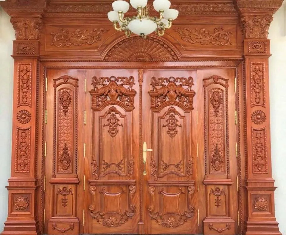 Mẫu cửa gỗ 4 cánh không đều với thiết kế chạm khắc uy nghi thích hợp cho các tòa nhà lớn
